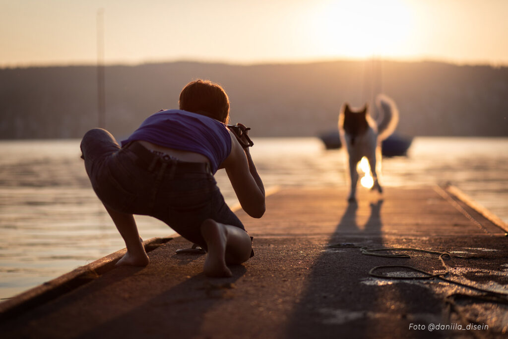 Fotografin und Hund beim Outdoor-Shooting in der Natur, noch kaum Licht am Himmel