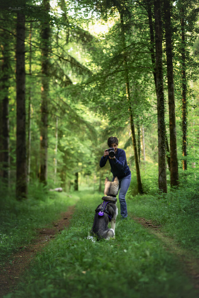 Manuela Klaeui im Wald beim Fotografieren ihrer Huendin Abby
